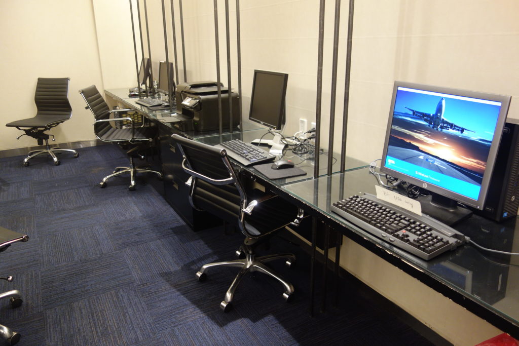 a computer desk with computers and chairs