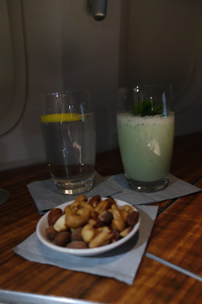 a bowl of nuts and a drink on a table