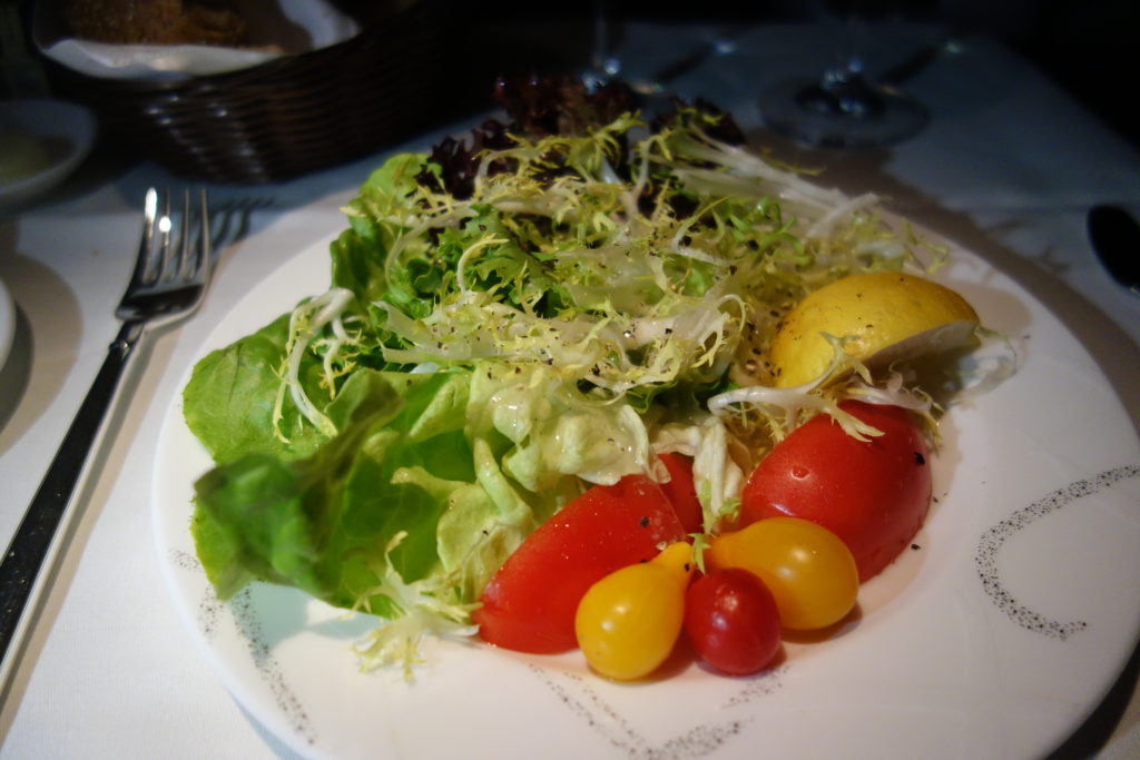 a plate of salad with tomatoes and lettuce