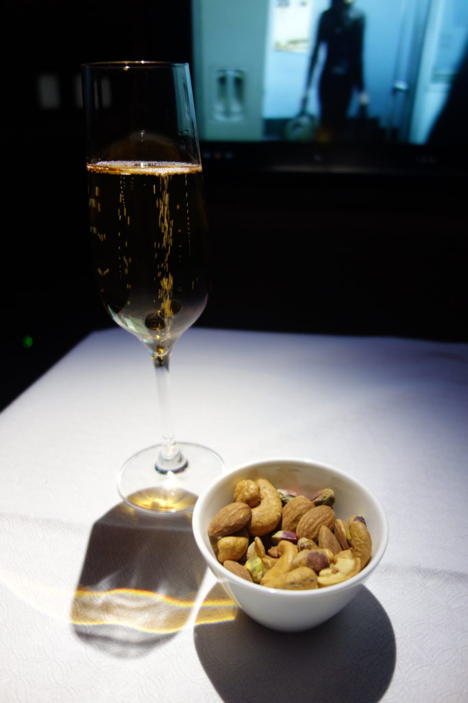 a glass of champagne and a bowl of nuts