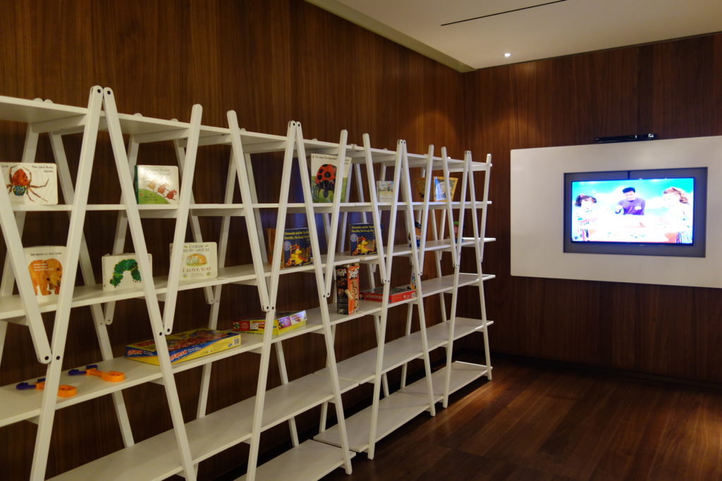 a white shelves with books and toys on them
