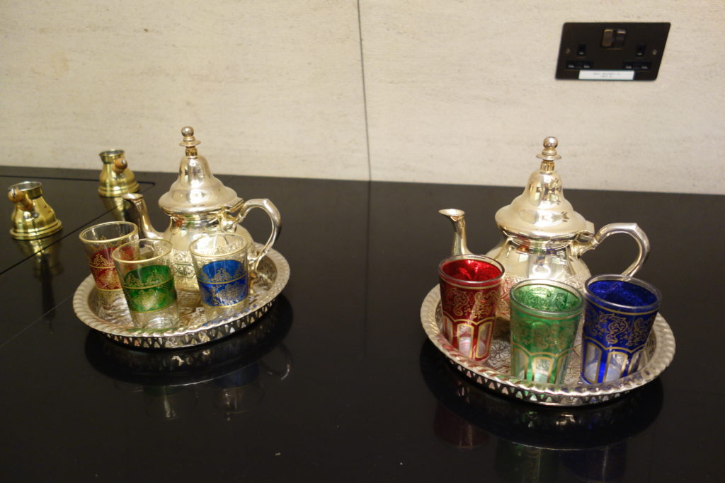 a silver tea set and glasses on a tray