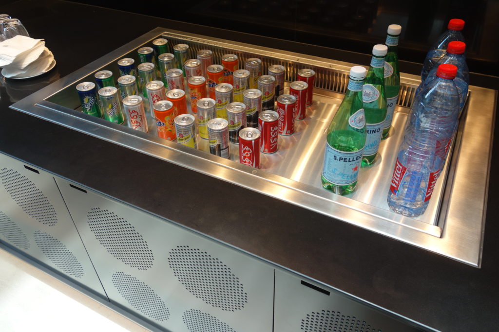 a group of soda cans and bottles in a cooler