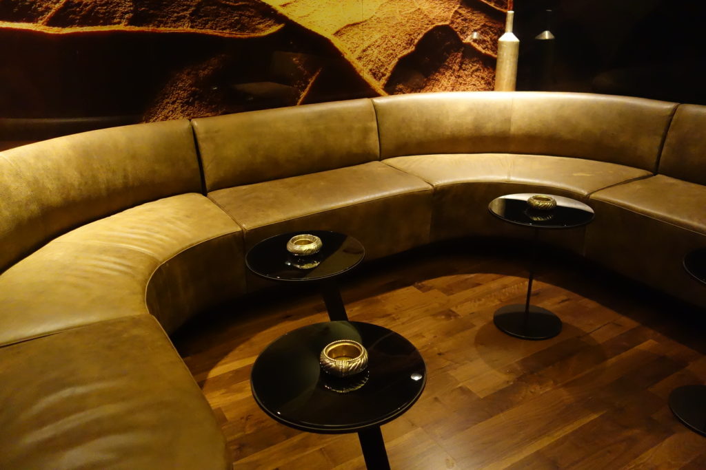 a couch with a table and two small round tables