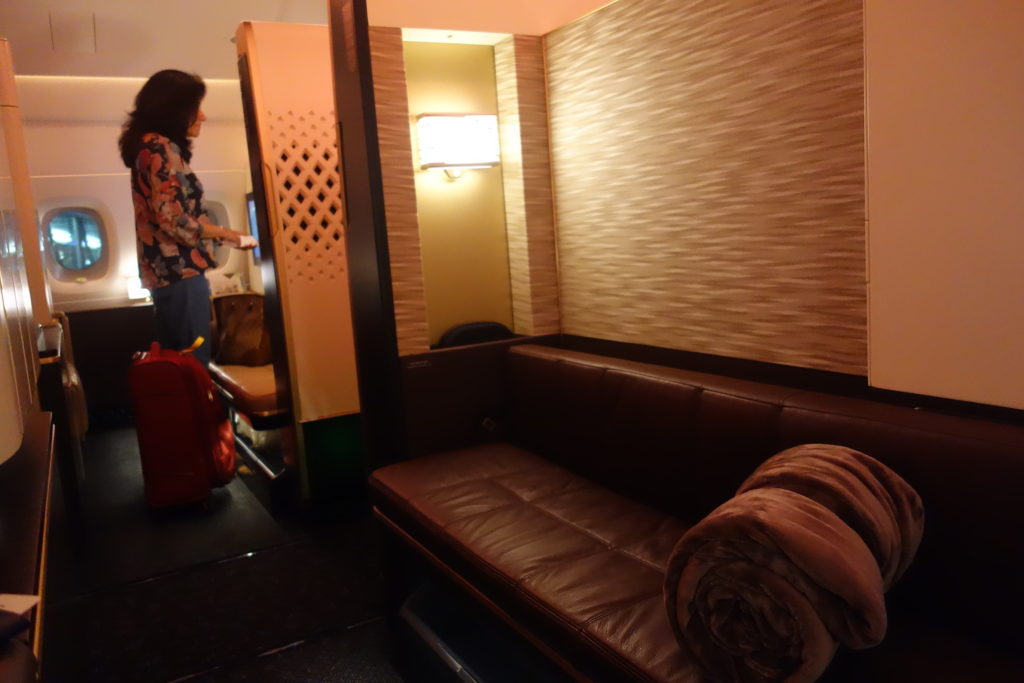 a woman standing in a room with a couch and luggage