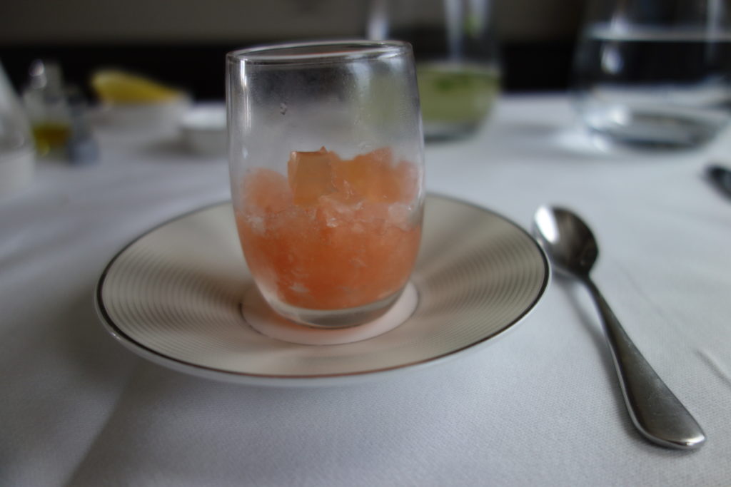 a glass with orange substance on a plate