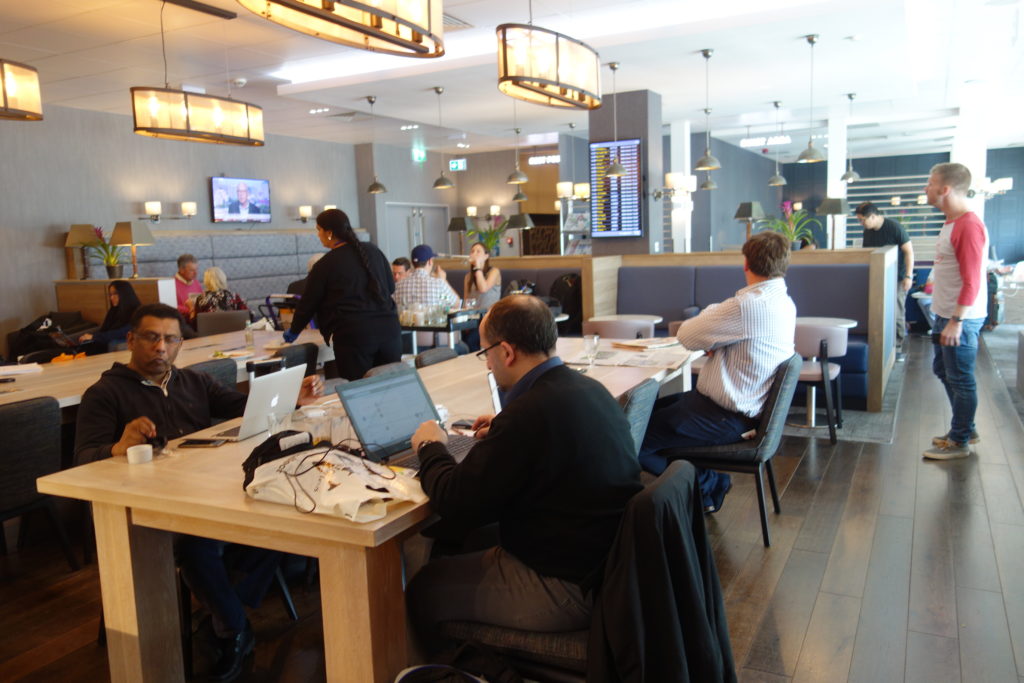 a group of people sitting at tables with laptops