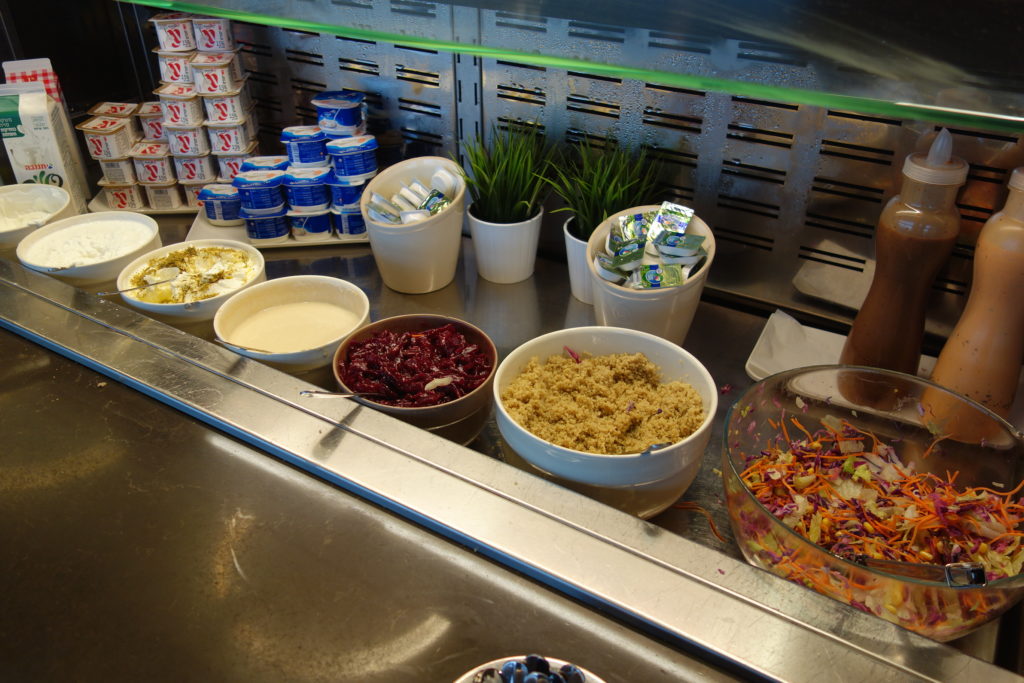 a counter with bowls of food and yogurt