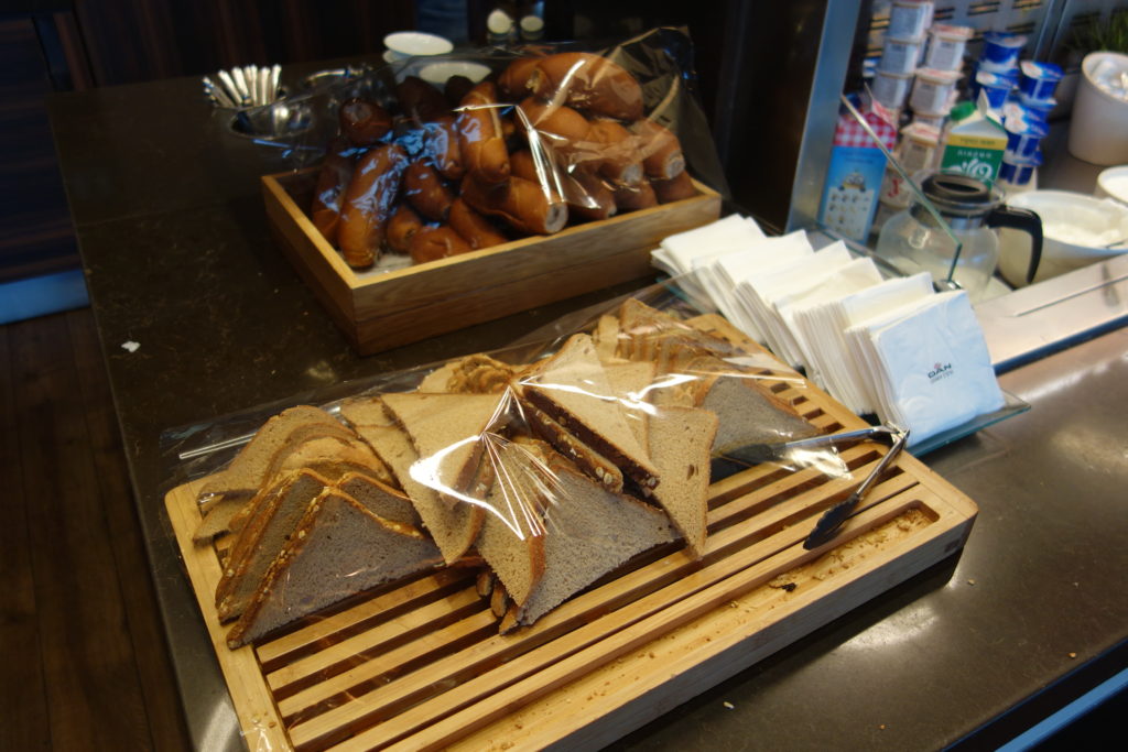 sandwiches on a wooden tray with a tray of bread and napkins