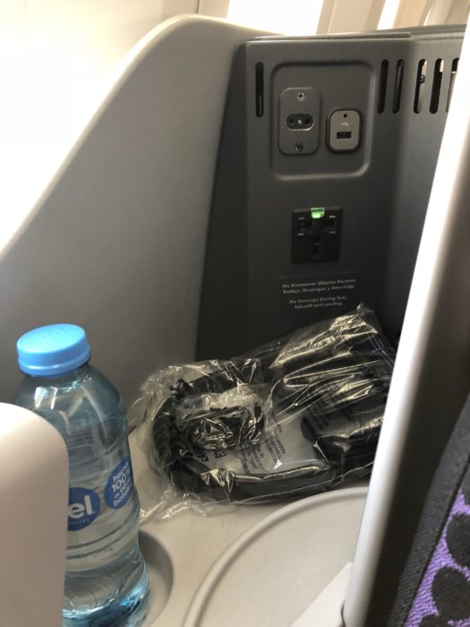 a plastic bag with a power outlet and a bottle of water
