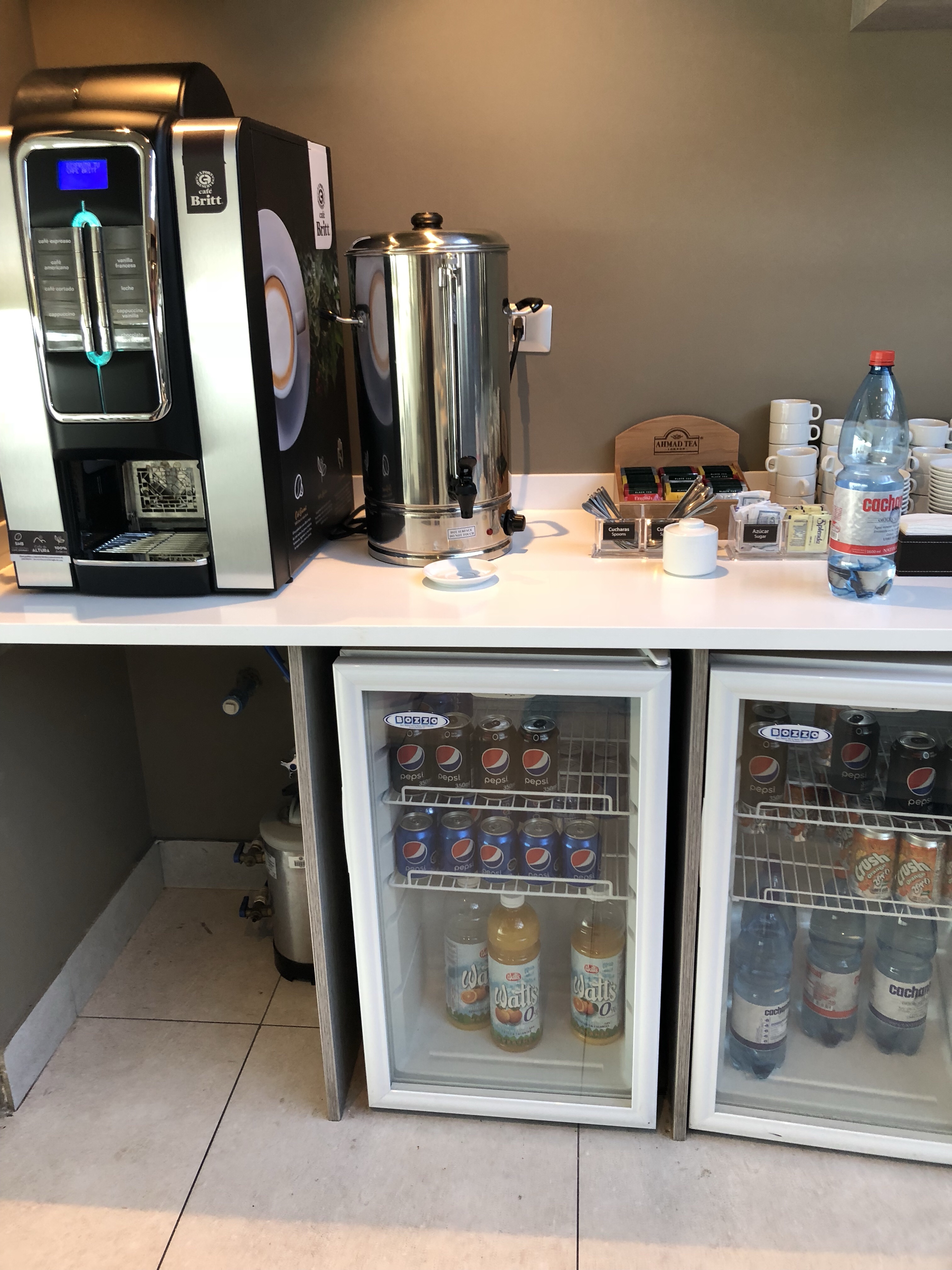a refrigerator and beverage dispenser on a counter