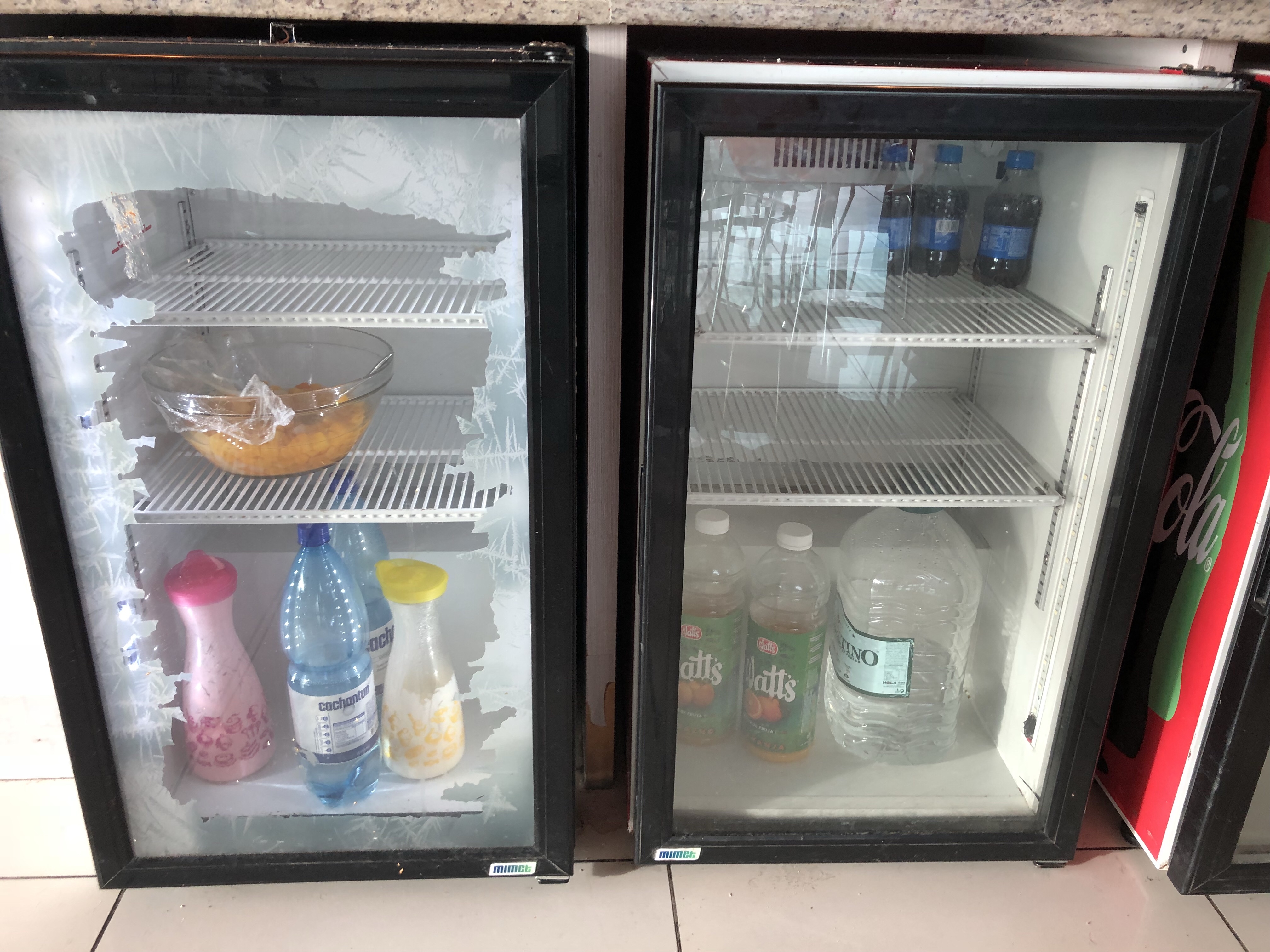 two refrigerators with bottles and bottles